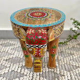 A hand-crafted wooden elephant stool with a hand-painted design, featuring floral patterns and global style accents on a 12-inch tall stool.