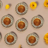 Wooden coasters with decorative patterns on a beige background with yellow flowers.