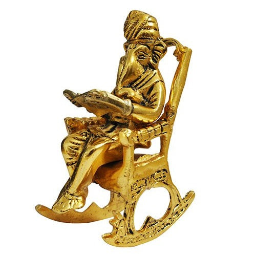 Lord Ganesha Statue Sitting on A Chair And Reading Ramayan