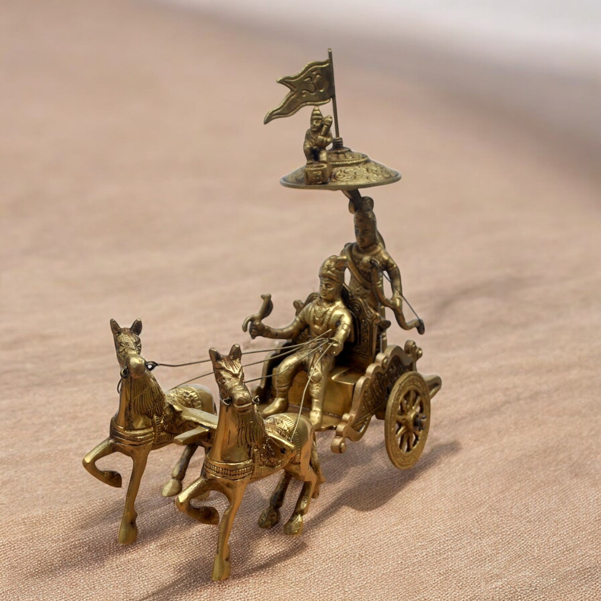 Bronze chariot with horses and figures on a beige background