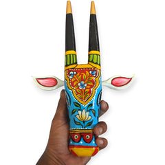 Decorative wall art with colorful patterns held by a hand on a white background